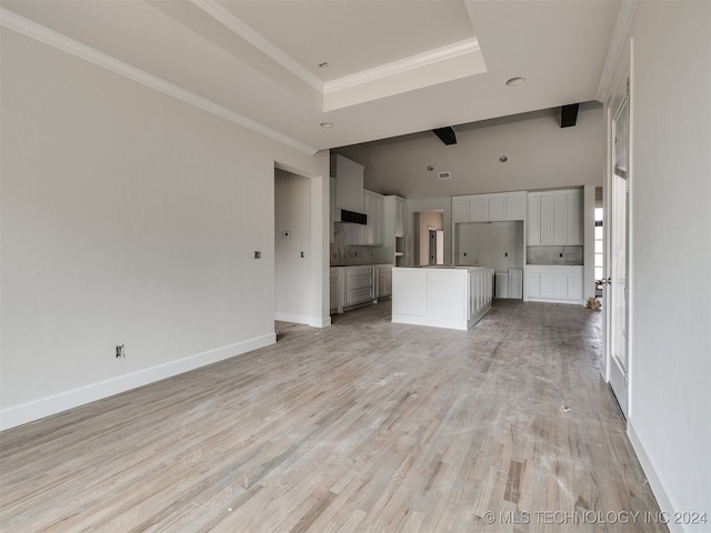 unfurnished living room with beamed ceiling, light hardwood / wood-style floors, a raised ceiling, and crown molding