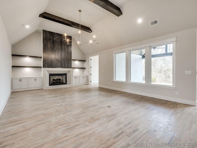 unfurnished living room featuring an inviting chandelier, a fireplace, built in features, and light wood-type flooring