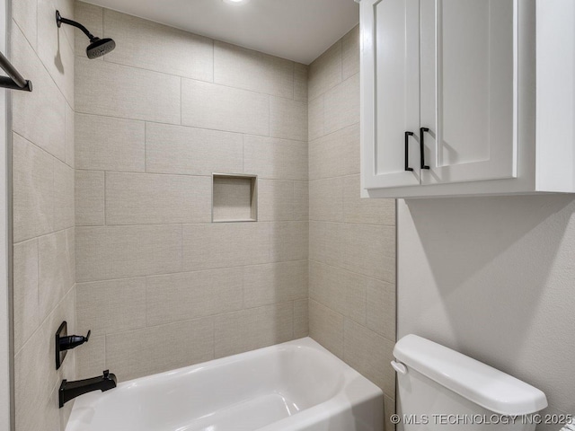 bathroom with tiled shower / bath combo and toilet