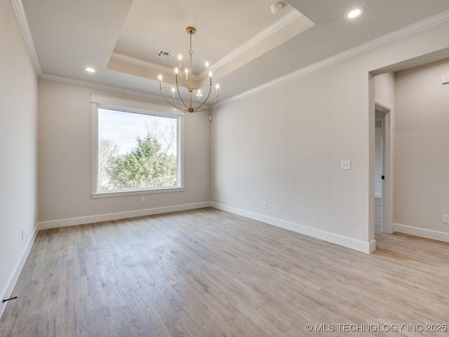 spare room featuring an inviting chandelier, light hardwood / wood-style flooring, ornamental molding, and a raised ceiling