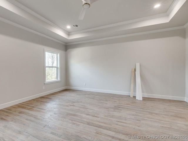 unfurnished room featuring crown molding, ceiling fan, a raised ceiling, and light hardwood / wood-style floors