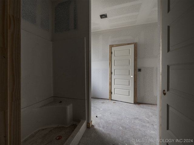 bathroom featuring a bath and concrete flooring