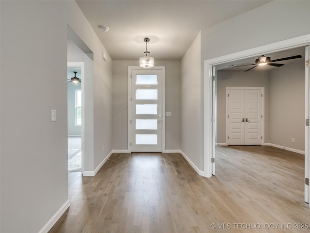 foyer entrance with wood finished floors, baseboards, and ceiling fan