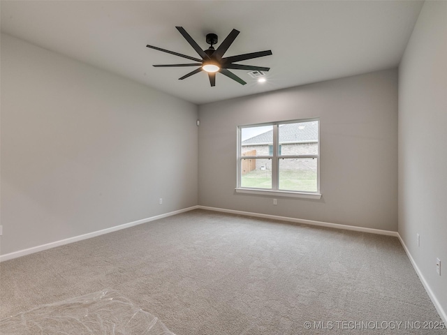 carpeted empty room with visible vents, a ceiling fan, and baseboards