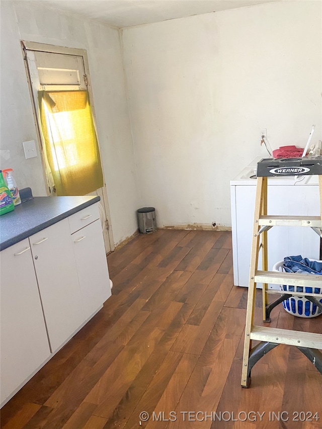 interior space featuring washer / clothes dryer, white cabinetry, and dark wood-type flooring