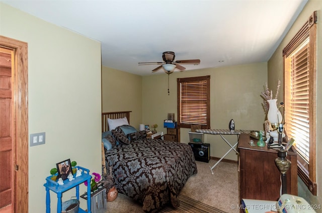 bedroom featuring multiple windows, ceiling fan, and carpet floors