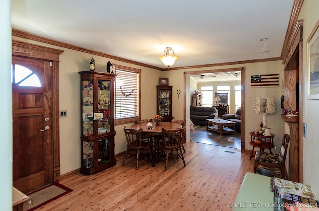 dining room with plenty of natural light, light hardwood / wood-style floors, and ornamental molding