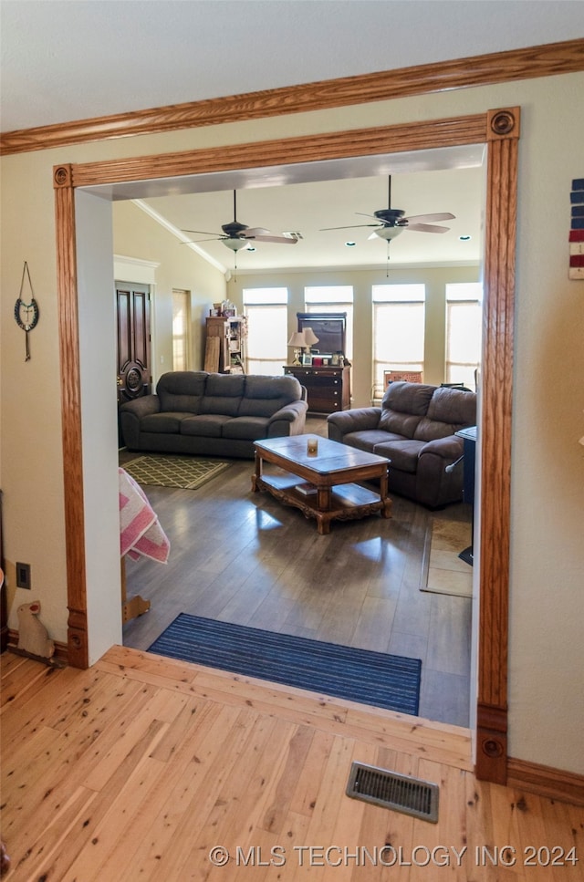 living room with wood-type flooring and crown molding