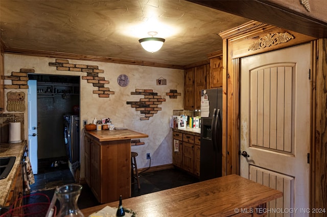 kitchen featuring wood counters, ornamental molding, and stainless steel refrigerator with ice dispenser