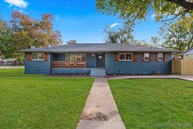 ranch-style house featuring covered porch and a front lawn