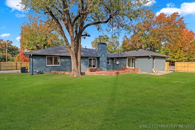 back of property featuring a yard and central AC