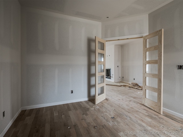 empty room with french doors and hardwood / wood-style flooring