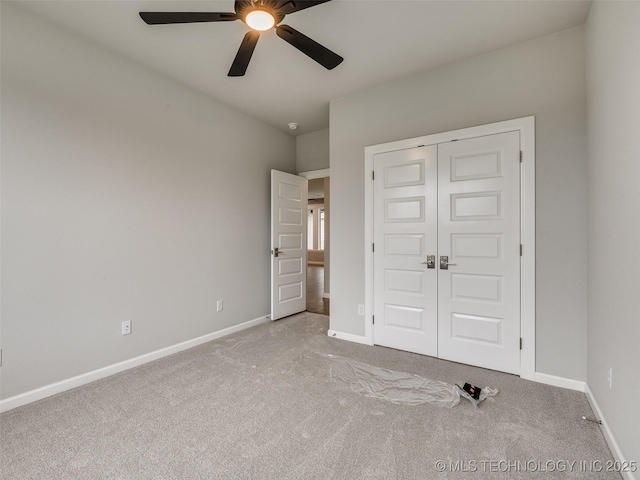unfurnished bedroom with baseboards, carpet, a closet, and ceiling fan
