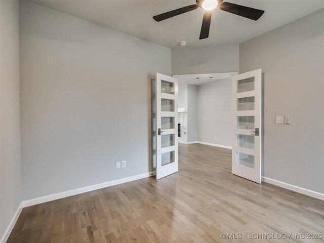 unfurnished room with baseboards, french doors, wood finished floors, and a ceiling fan