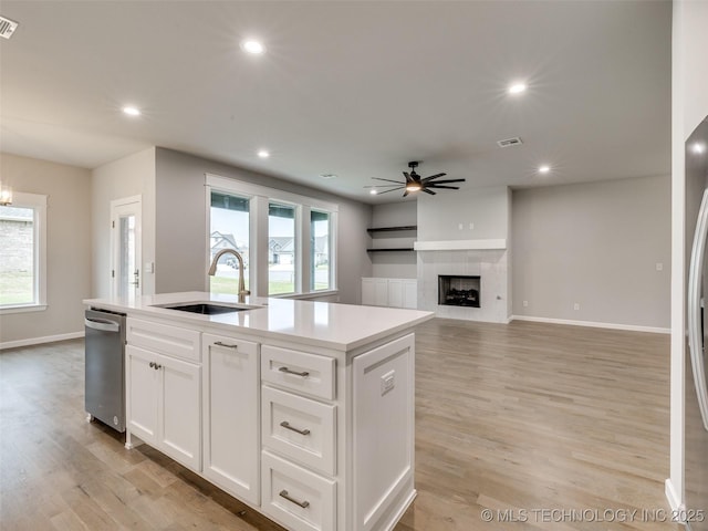kitchen with a ceiling fan, a sink, a kitchen island with sink, and plenty of natural light