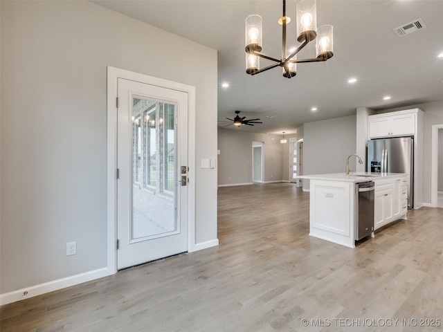 kitchen featuring open floor plan, baseboards, white cabinetry, and visible vents