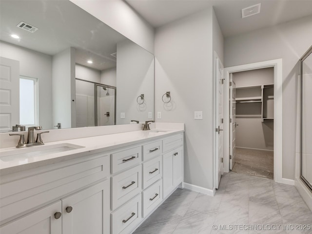 bathroom with visible vents, marble finish floor, a stall shower, and a sink