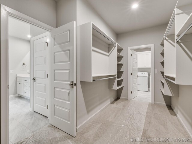 spacious closet featuring light carpet and washer / clothes dryer