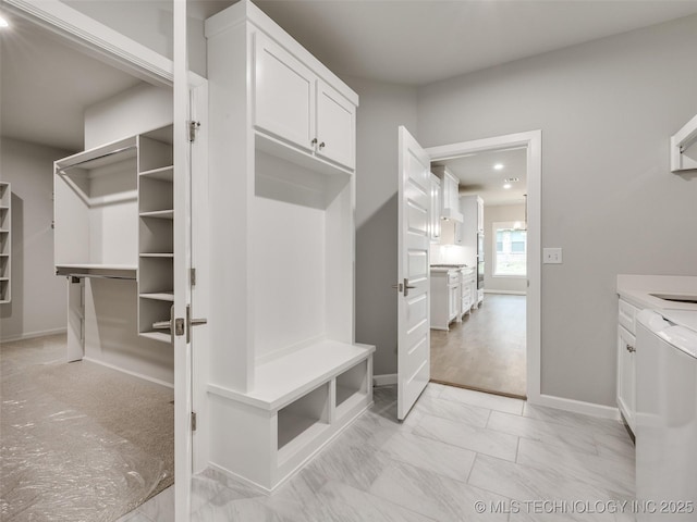mudroom with baseboards and marble finish floor