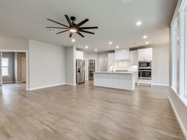unfurnished living room with light wood-style flooring, baseboards, visible vents, recessed lighting, and ceiling fan
