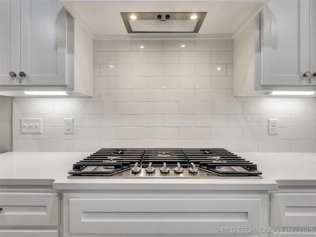 interior space with light countertops, white cabinetry, and tasteful backsplash