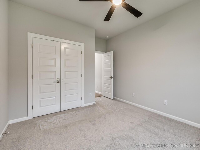 unfurnished bedroom with baseboards, carpet, a closet, and ceiling fan
