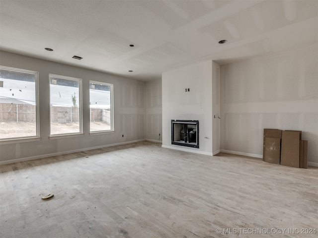 unfurnished living room with a fireplace and light hardwood / wood-style floors