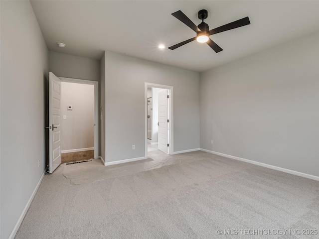 unfurnished bedroom with ceiling fan, baseboards, light colored carpet, and ensuite bathroom