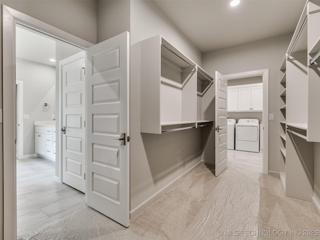 spacious closet featuring light carpet and washer and clothes dryer