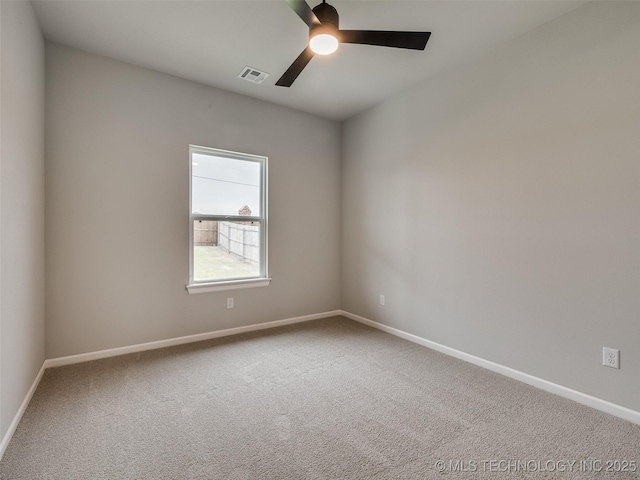 empty room with baseboards, a ceiling fan, visible vents, and carpet floors