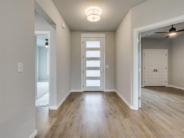 foyer entrance with baseboards, wood finished floors, and ceiling fan