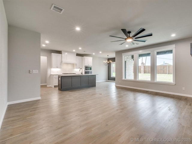 unfurnished living room with baseboards, visible vents, and recessed lighting