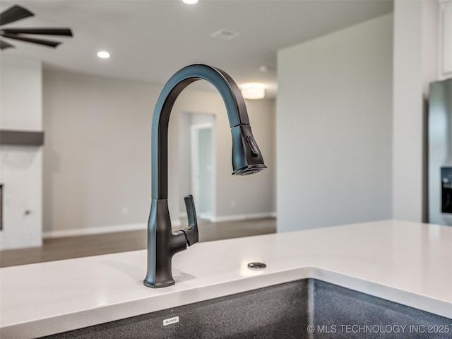 interior details featuring recessed lighting, light countertops, a ceiling fan, and a sink