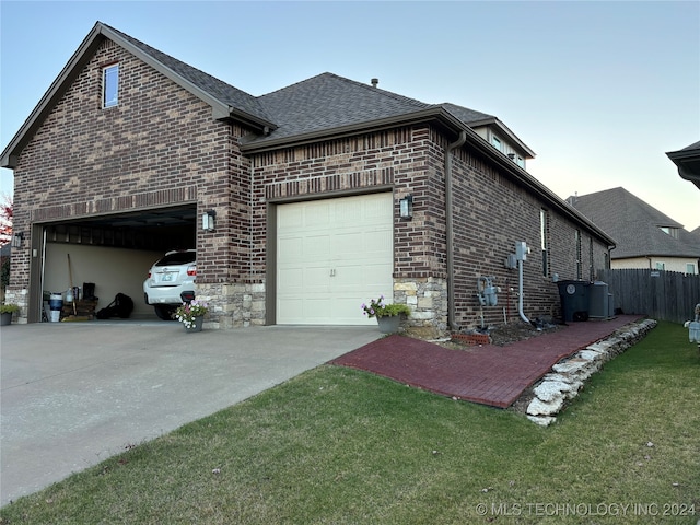 view of property exterior with a garage, cooling unit, and a lawn