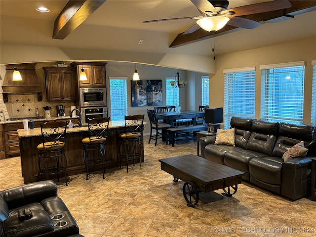 living room with beamed ceiling, ceiling fan, and sink