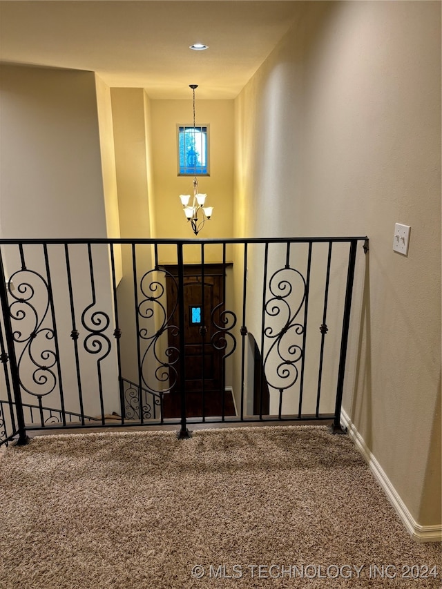 stairs with carpet and a chandelier