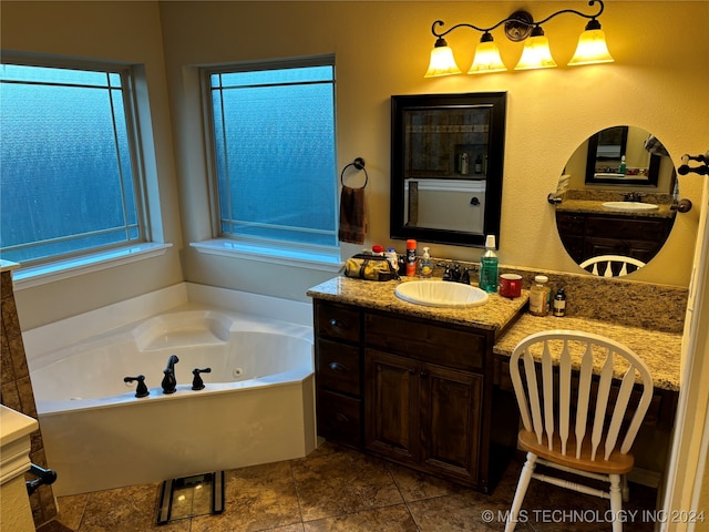 bathroom with a bathing tub, tile patterned flooring, vanity, and a wealth of natural light