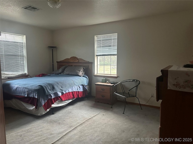 bedroom featuring baseboards, visible vents, and light colored carpet