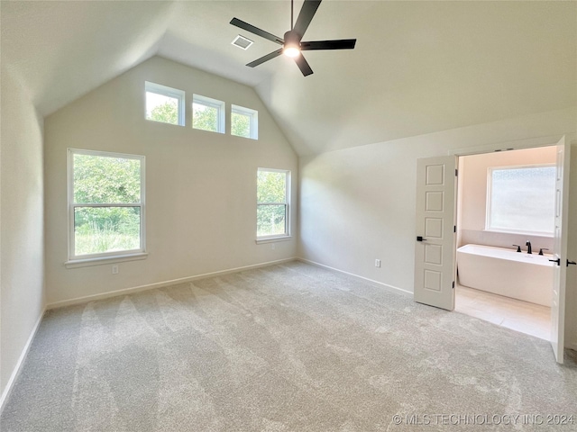 interior space featuring baseboards, visible vents, a ceiling fan, light colored carpet, and high vaulted ceiling