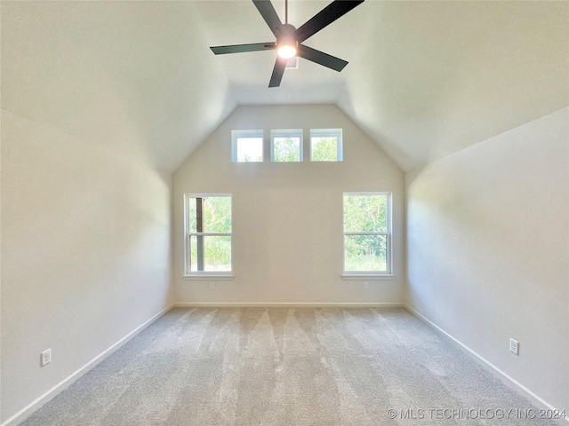 bonus room featuring lofted ceiling, plenty of natural light, baseboards, and light colored carpet