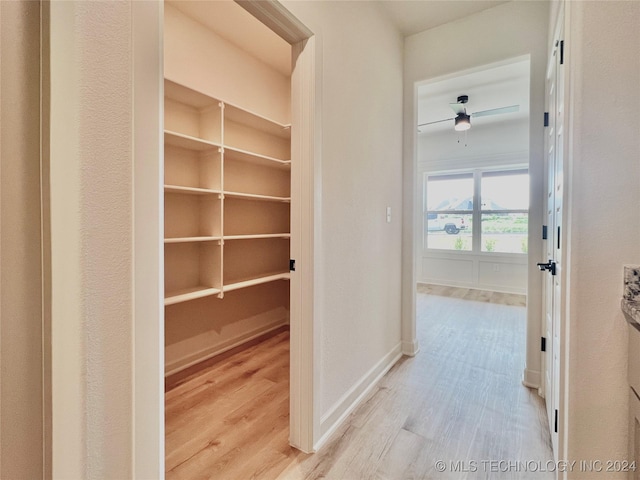 corridor with light wood-style floors and baseboards