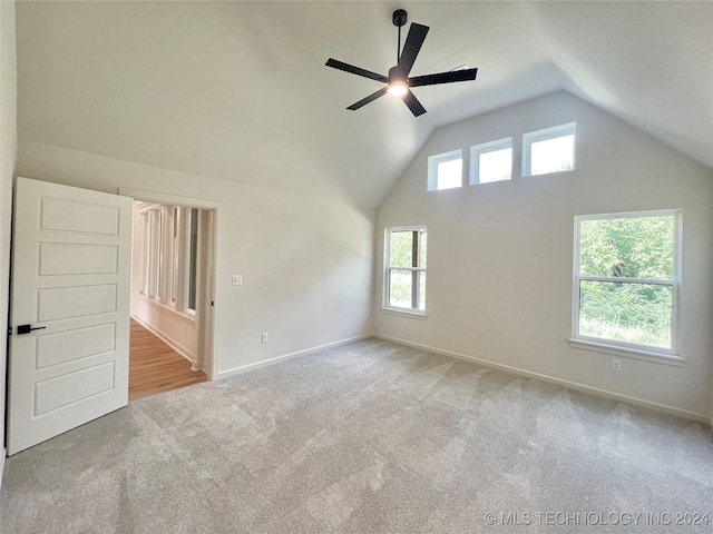 additional living space featuring light carpet, ceiling fan, baseboards, and vaulted ceiling