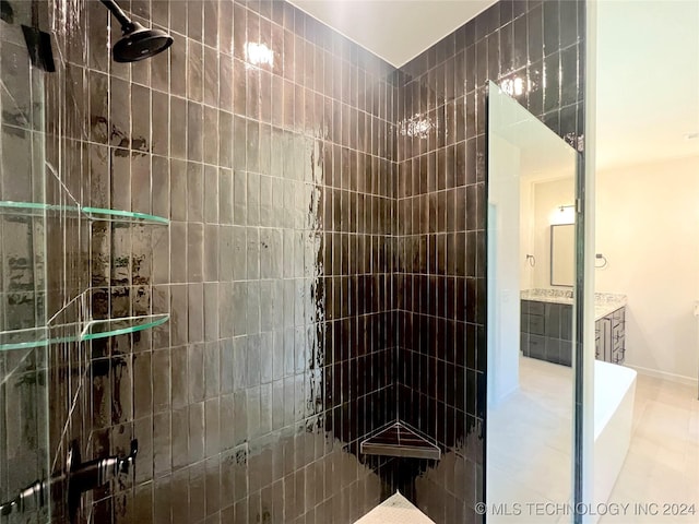 full bathroom featuring a tile shower and vanity