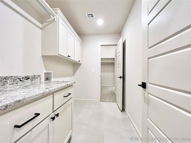 washroom with cabinet space, baseboards, hookup for a washing machine, and visible vents