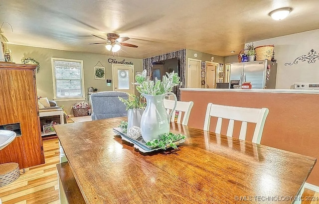 dining space with light hardwood / wood-style floors and ceiling fan