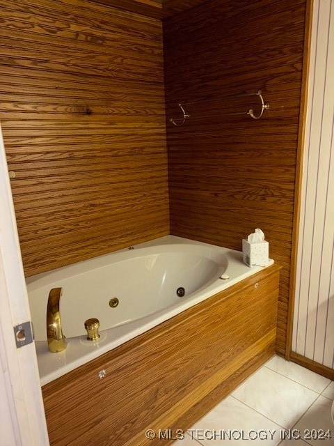 bathroom with tile patterned flooring and tiled bath