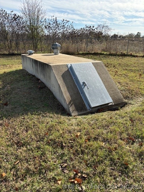 view of storm shelter featuring a lawn