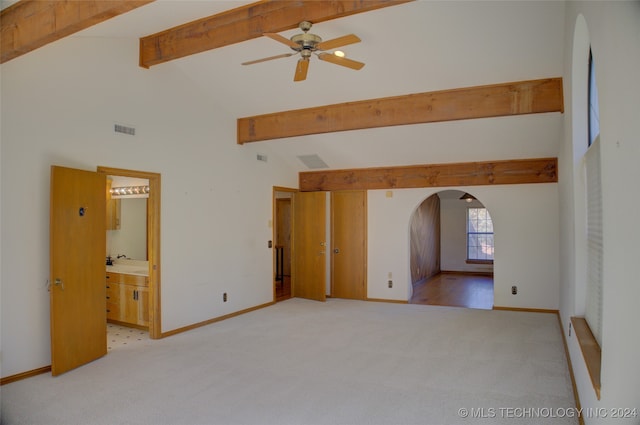 interior space with beam ceiling, high vaulted ceiling, and light colored carpet