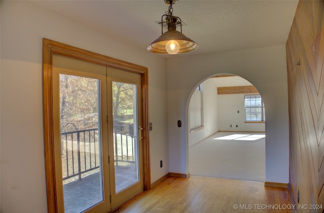 entryway with a textured ceiling and light wood-type flooring