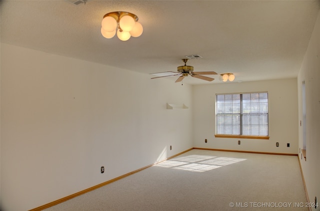 carpeted empty room featuring ceiling fan and a textured ceiling